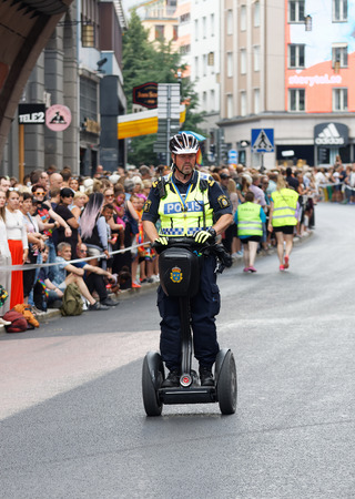 STOCKHOLM, SWEDEN - JUL 30, 2016: One male police officer patroling the street on a seagway in the Pride parade July 30, 2016 in Stockholm, Swedenのeditorial素材