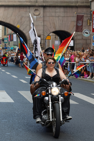 STOCKHOLM, SWEDEN - JUL 30, 2016: Two woman dressed in leather clothes on a motorcycle decorated with pride flags in the Pride parade July 30, 2016 in Stockholm, Swedenのeditorial素材