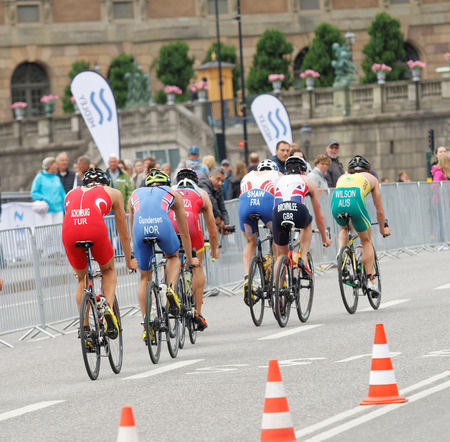 STOCKHOLM, SWEDEN - JUL 02, 2016: Rear view of a group of male triathlete cyclists in the Men's ITU World Triathlon series event July 02, 2016 in Stockholm, Swedenのeditorial素材