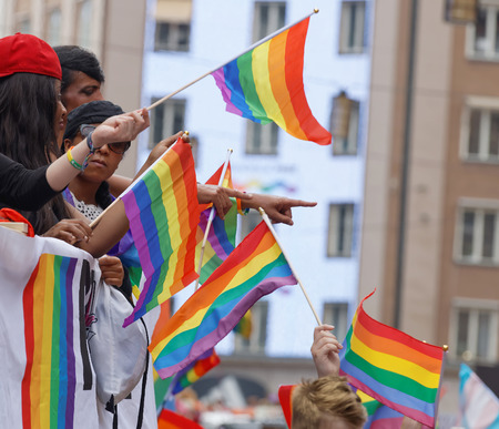 STOCKHOLM, SWEDEN - JUL 30, 2016: Hands waiving the colorful rainbow pride flag in the Pride parade July 30, 2016 in Stockholm, Swedenのeditorial素材