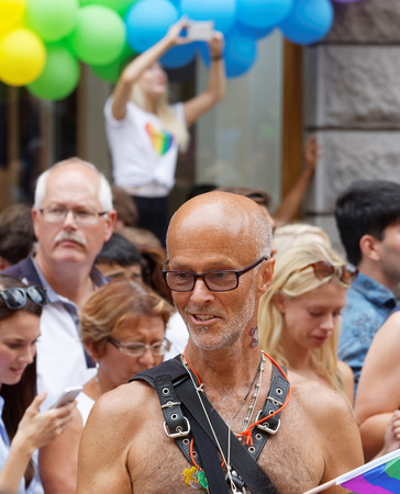 STOCKHOLM, SWEDEN - JUL 30, 2016: GSenior macho man dressed in leather belts on the torsoeather wearing sunglasses standing on a truck bed in the Pride parade July 30, 2016 in Stockholm, Swedenのeditorial素材