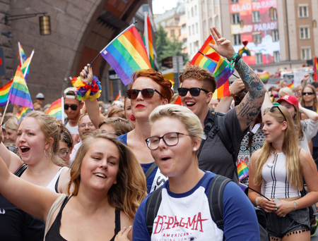 STOCKHOLM, SWEDEN - JUL 30, 2016: Girls and boys waiving the rainbow Pride flags in the Pride parade July 30, 2016 in Stockholm, Swedenのeditorial素材