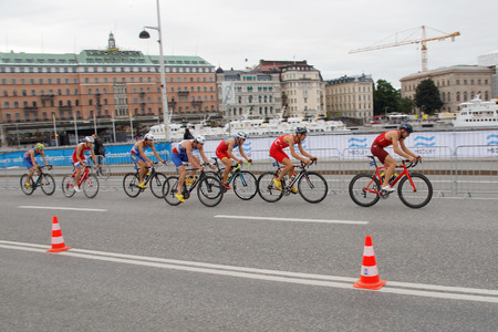 STOCKHOLM, SWEDEN - JUL 02, 2016: Group of colorful male triathlete cyclists on a bridge in the Men's ITU World Triathlon series event July 02, 2016 in Stockholm, Swedenのeditorial素材