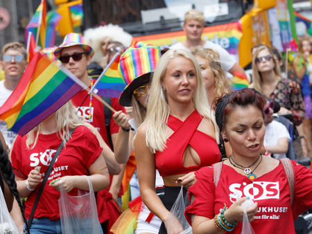 STOCKHOLM, SWEDEN - JUL 30, 2016: Young blonde girl wearing a spectacular red shirt in the Pride parade July 30, 2016 in Stockholm, Swedenのeditorial素材