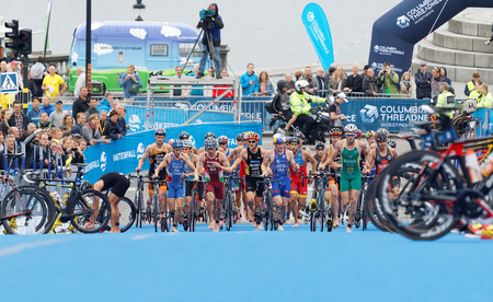 STOCKHOLM - JUL 02, 2016: Large group of running triathletes running with bicyles in the transition zone in the Men's ITU World Triathlon series event July 02, 2016 in Stockholm, Swedenのeditorial素材
