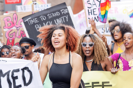 STOCKHOLM, SWEDEN - JUL 30, 2016: Demonstrating women with afro hair holding a signs in the Pride Parade in the Pride parade July 30, 2016 in Stockholm, Swedenのeditorial素材
