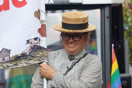 STOCKHOLM, SWEDEN - JUL 30, 2016: Senior smiling woman dressed as an retro farmer in the Pride parade July 30, 2016 in Stockholm, Swedenのeditorial素材