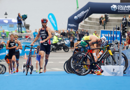 STOCKHOLM - JUL 02, 2016: Triathlete Adam Bowden and competitors running with bicyle in the transition zone in the Men's ITU World Triathlon series event July 02, 2016 in Stockholm, Swedenのeditorial素材