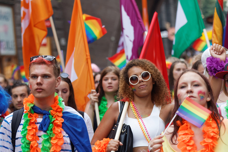 STOCKHOLM, SWEDEN - JUL 30, 2016: Young, girls and boys waiving the rainbow pride flags in the Pride parade July 30, 2016 in Stockholm, Swedenのeditorial素材