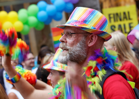 STOCKHOLM, SWEDEN - JUL 30, 2016: Senior man with beard wearing a rainbow hat, colorful background in the Pride parade July 30, 2016 in Stockholm, Swedenのeditorial素材