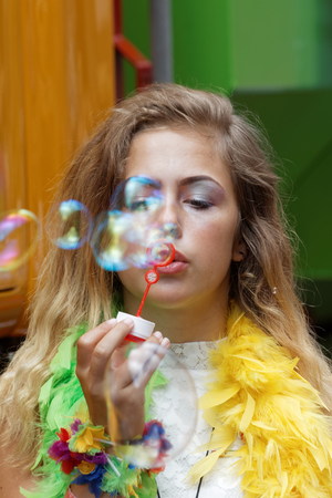STOCKHOLM, SWEDEN - JUL 30, 2016: Young girl making bubbles, colorful background in the Pride parade July 30, 2016 in Stockholm, Swedenのeditorial素材