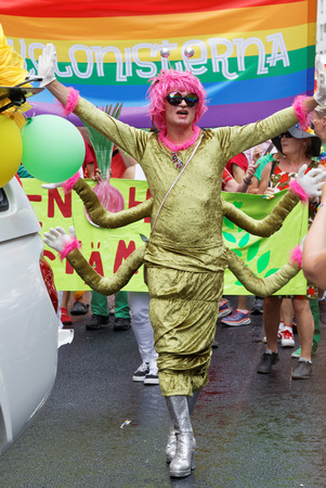 STOCKHOLM, SWEDEN - JUL 30, 2016: Senior smiling transvestite man with a pink wig dressed as a centipede in the Pride parade July 30, 2016 in Stockholm, Swedenのeditorial素材