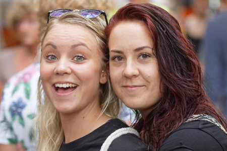 STOCKHOLM, SWEDEN - JUL 30, 2016: Two happy girls in the audience of the pride parade in the Pride parade July 30, 2016 in Stockholm, Swedenのeditorial素材