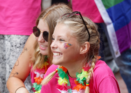 STOCKHOLM, SWEDEN - JUL 30, 2016: Two young happy girls smiling, colorful background in the Pride parade July 30, 2016 in Stockholm, Swedenのeditorial素材