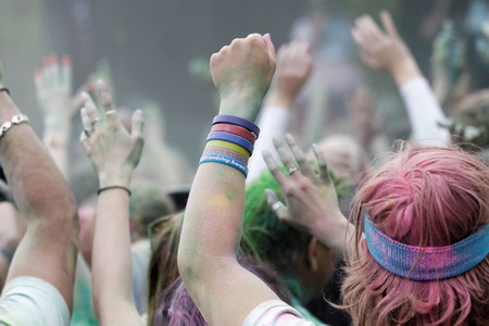 STOCKHOLM, SWEDEN - MAY 22, 2016: Happy audience with arms in the air and color powder in the air in the Color Run Event in Sweden, May 22, 2016のeditorial素材