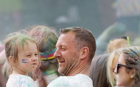 STOCKHOLM, SWEDEN - MAY 22, 2016: Young girl with paint in her face carried by her father in the Color Run Event in Sweden, May 22, 2016のeditorial素材