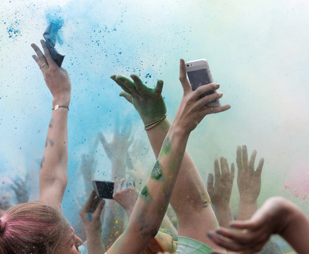 STOCKHOLM, SWEDEN - MAY 22, 2016: Closeup of happy hands throughing blue color powder in the air in the Color Run Event in Sweden, May 22, 2016のeditorial素材