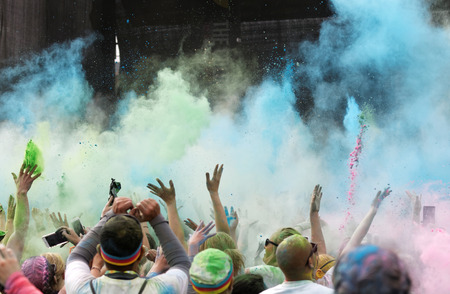 STOCKHOLM, SWEDEN - MAY 22, 2016: Happy audience with arms in the air and blue color powder in the air in the Color Run Event in Sweden, May 22, 2016のeditorial素材
