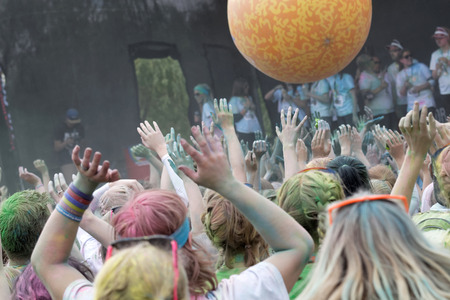 STOCKHOLM, SWEDEN - MAY 22, 2016: Happy audience with arms in the air and color powder in the air in the Color Run Event in Sweden, May 22, 2016のeditorial素材