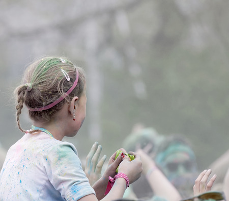 STOCKHOLM, SWEDEN - MAY 22, 2016: YYoung girl with paint in her hair on her mothers shoulders in the Color Run Event in Sweden, May 22, 2016のeditorial素材