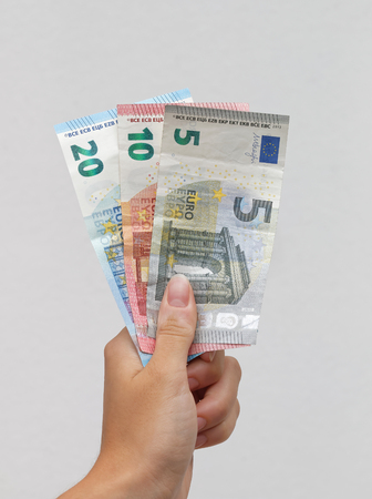 Hand holding Euro banknotes to another handの写真素材