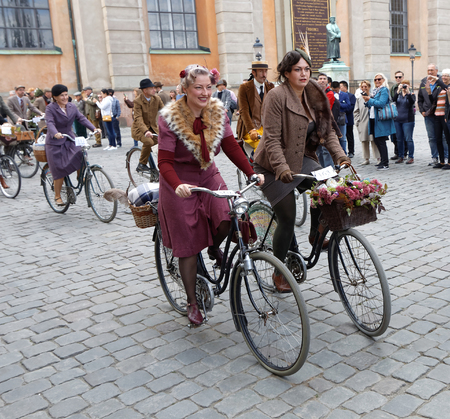 STOCKHOLM - SEPT 24, 2016: Smiling cycling women dressed in old fashioned dress in the Bike in tweed event September 24, 2016 in Stockholm, Swedenのeditorial素材