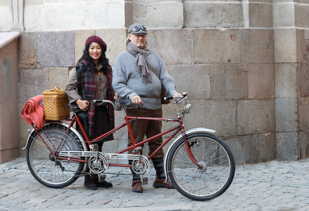 STOCKHOLM - SEPT 24, 2016: Woman and man wearing old fashioned clothes in front of a tandem bicycle in Tweed event September 24, 2016 in Stockholm, Swedenのeditorial素材