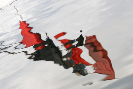 Unsharp red and black fishing flags reflecting in waterの写真素材
