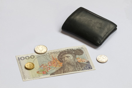 Swedish currency 1000 SEK, coints and black wallet on a white tableの写真素材