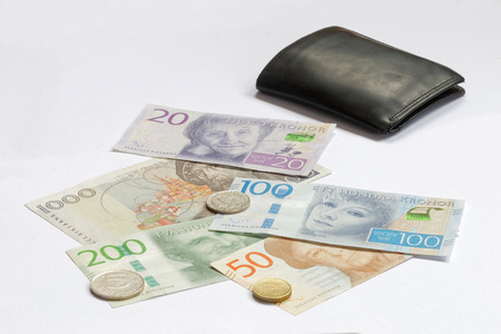 Swedish currency SEK, banknotes, coints and black wallet on a white tableの写真素材