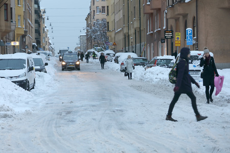 STOCKHOLM, SWEDEN - NOV 10, 2016: Snow chaos in the traffic in central Stockholm.  Cars covered with snow and people walking, November 10, 2016 in Stockholm, Swedenのeditorial素材