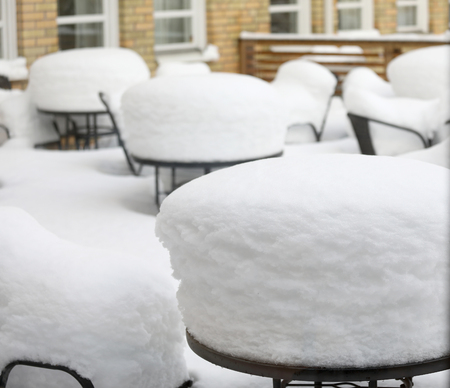 Tables and chairs coverd with a thick layer of snowの写真素材