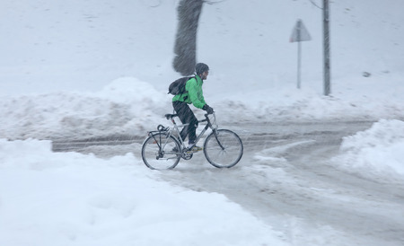 STOCKHOLM, SWEDEN - NOV 10, 2016: Snow chaos in the traffic. Bicyclist struggeling in the snow. November 10, 2016 in Stockholm, Swedenのeditorial素材