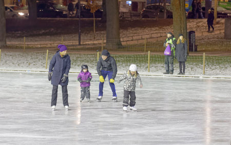 STOCKHOLM, SWEDEN - DEC 03 2016: Children and adults skating in the park during the night. Vasaparken, Stockholm, Swedenのeditorial素材
