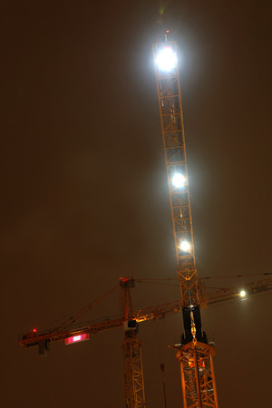 STOCKHOLM, SWEDEN - NOV 16 2016: Three yellow cranes in the yellow night light in Hagastaden,  Stockholm, November 16, 2016のeditorial素材