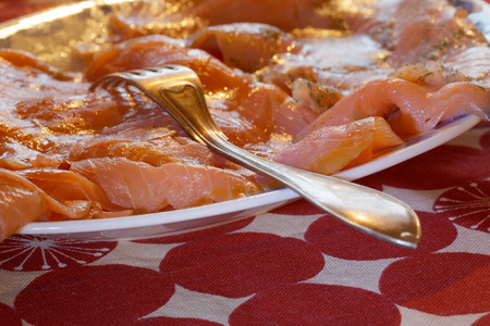 Plate of smoked salmon on the Christmas table with a red cloth and a silver fork
の写真素材