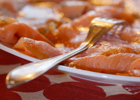 Plate of smoked salmon on the Christmas table with a red cloth and a silver fork
の写真素材