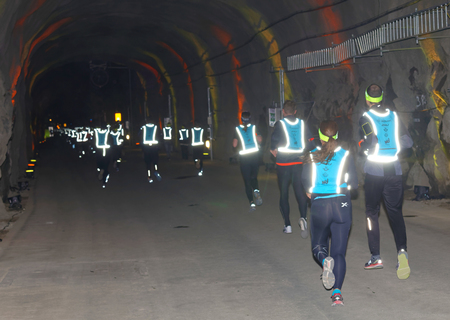 STOCKHOLM, SWEDEN - MAR 25, 2017: Rear view of many runners in reflex vest in a dark tunnel in the Stockholm Tunnel Run Citybanan 2017. March 25, 2017 in Stockholm, Swedenのeditorial素材