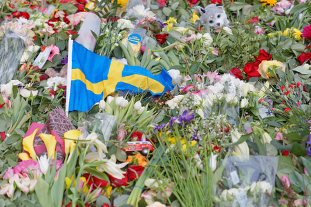 STOCKHOLM, SWEDEN - APR 12, 2017: Flowers and swedish flag from people paying respect to the victims in the terror attack in Stockholm April 07, 2017. April 13, 2017 in Stockholm, Swedenのeditorial素材