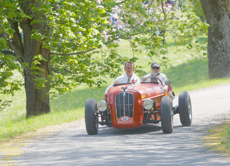 STOCKHOLM, SWEDEN - MAY 22, 2017: Red Rundbaneracer classic car from 1957 driving on a country road in the public race Gardesloppet in the forests at Djurgarden, Stockholm, Sweden. May 22, 2017のeditorial素材