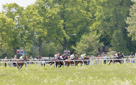 STOCKHOLM, SWEDEN - JUNE 06, 2017: Side view of many distant jockey riding brown arabian race horses at Nationaldags Galoppen at Gardet. June 6, 2017 in Stockholm, Swedenのeditorial素材