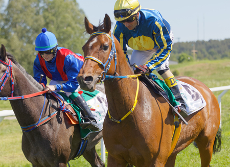 STOCKHOLM, SWEDEN - JUNE 06, 2017: Two  jockeys riding arabian race horses after the gallop race at Nationaldags Galoppen at Gardet. June 6, 2017 in Stockholm, Swedenのeditorial素材