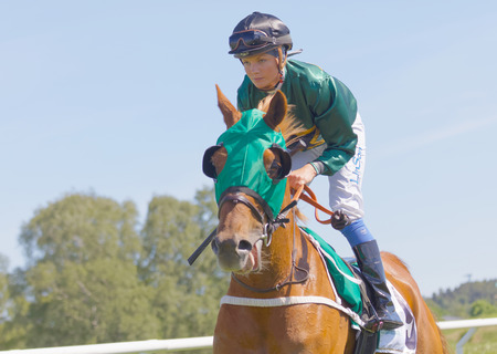 STOCKHOLM, SWEDEN - JUNE 06, 2017: Closeup of a female jockey riding a brown arabian race horse at Nationaldags Galoppen at Gardet. June 6, 2017 in Stockholm, Swedenのeditorial素材