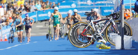STOCKHOLM - AUG 26, 2017: Parked cycles and female triathlete in the background in the transition zone in the Women's ITU World Triathlon series event August 26, 2017 in Stockholm, Swedenのeditorial素材