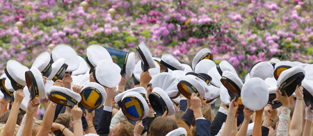STOCKHOLM, SWEDEN - JUN 13, 2017: Hands holding many swedish white graduation caps, lilac flowers in the background at the dance school Balettakademien, June 13 2017,Stockholm,Swedenのeditorial素材
