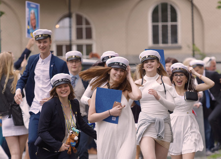 STOCKHOLM, SWEDEN - JUN 13, 2017: Happy teenagers wearing graduation caps running out from school after graduation at the school Norra Real, June 13 2017,Stockholm,Swedenのeditorial素材