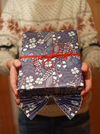 Man giving a Christmas present decorated with red ribbon. Short depth of focusの写真素材