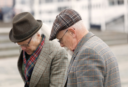 STOCKHOLM - SEPT 23, 2017: Two senior men dressed in old fashioned tweed jackets and hats in the Bike in Tweed event September 23, 2017 in Stockholm, Swedenのeditorial素材