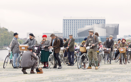 STOCKHOLM - SEPT 23, 2017: Many people holdin bicycles dressed in old fashioned tweed clothes in Central Stockholm at Riddarholmen in the Bike in Tweed event September 23, 2017 in Stockholm, Swedenのeditorial素材