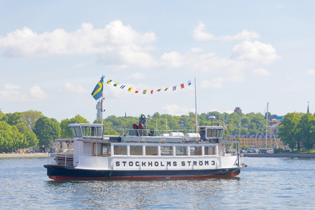 STOCKHOLM, SWEDEN - JUN 06, 2017: Steamboat with passengers, building and trees in the background in Stockholm, Sweden, June 06, 2017.のeditorial素材